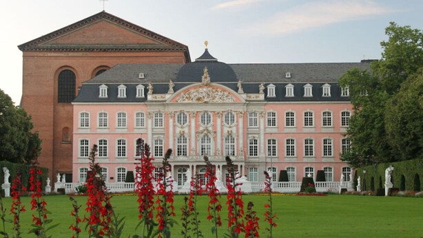 Un ampio edificio storico con facciata simmetrica, cupola centrale e stile architettonico classico.
