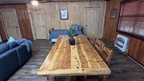 Un'area pranzo rustica in legno con una panca, un divano e una pianta in vaso.