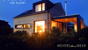 A modern house with a prominent entrance and large windows, surrounded by greenery. - Holiday Apartment in Thuringia (Zierow)