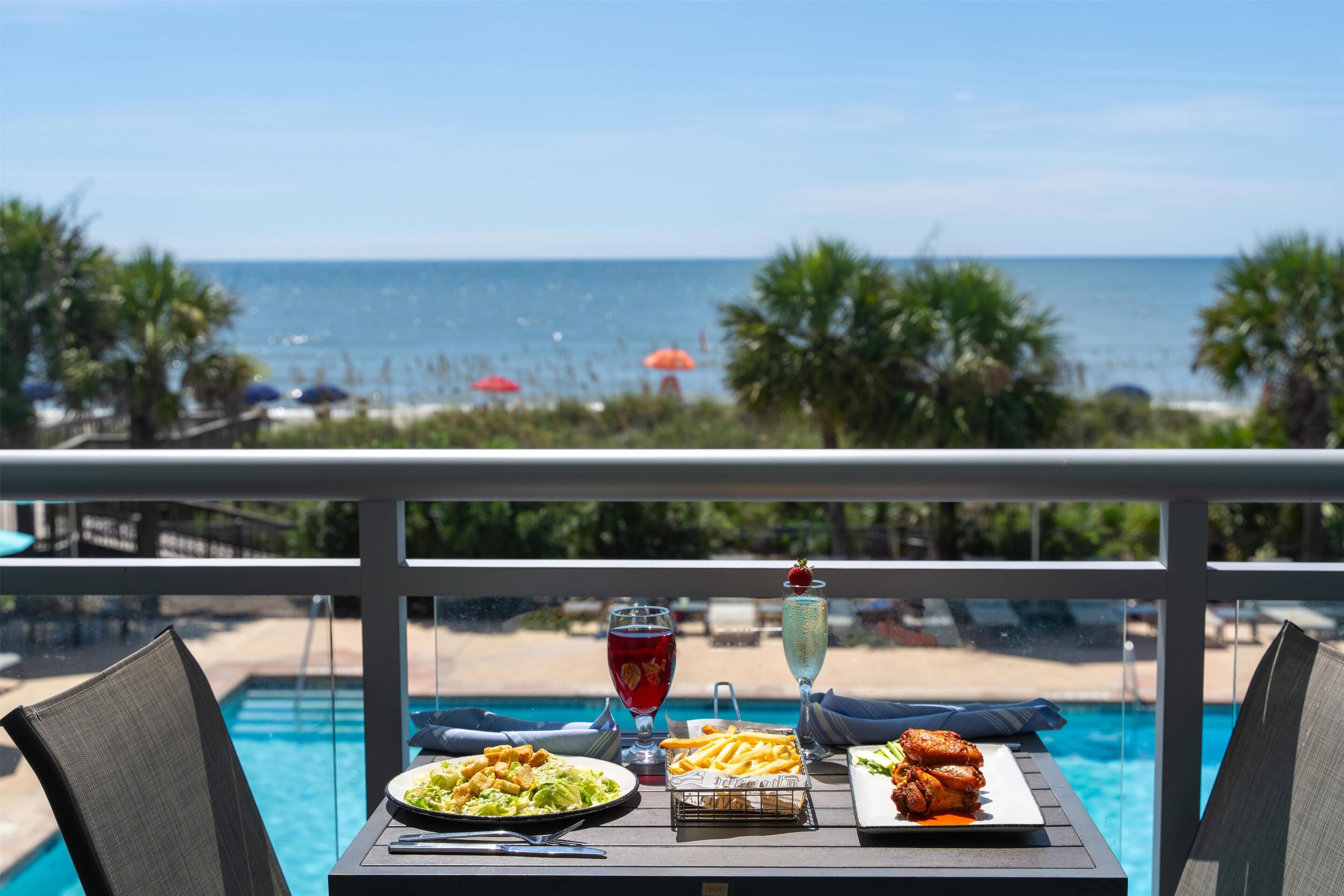 Ein Esstisch mit Blick auf das Meer und den Strand.