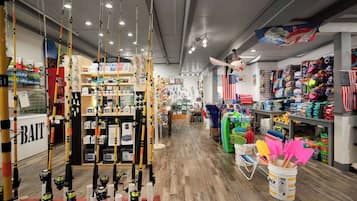A store with fishing rods, bait, and tackle organized on shelves and racks.