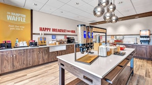 A modern breakfast area with a coffee station, a bakery, and a sign reading "HAPPY BREAKFAST STARTS HERE."