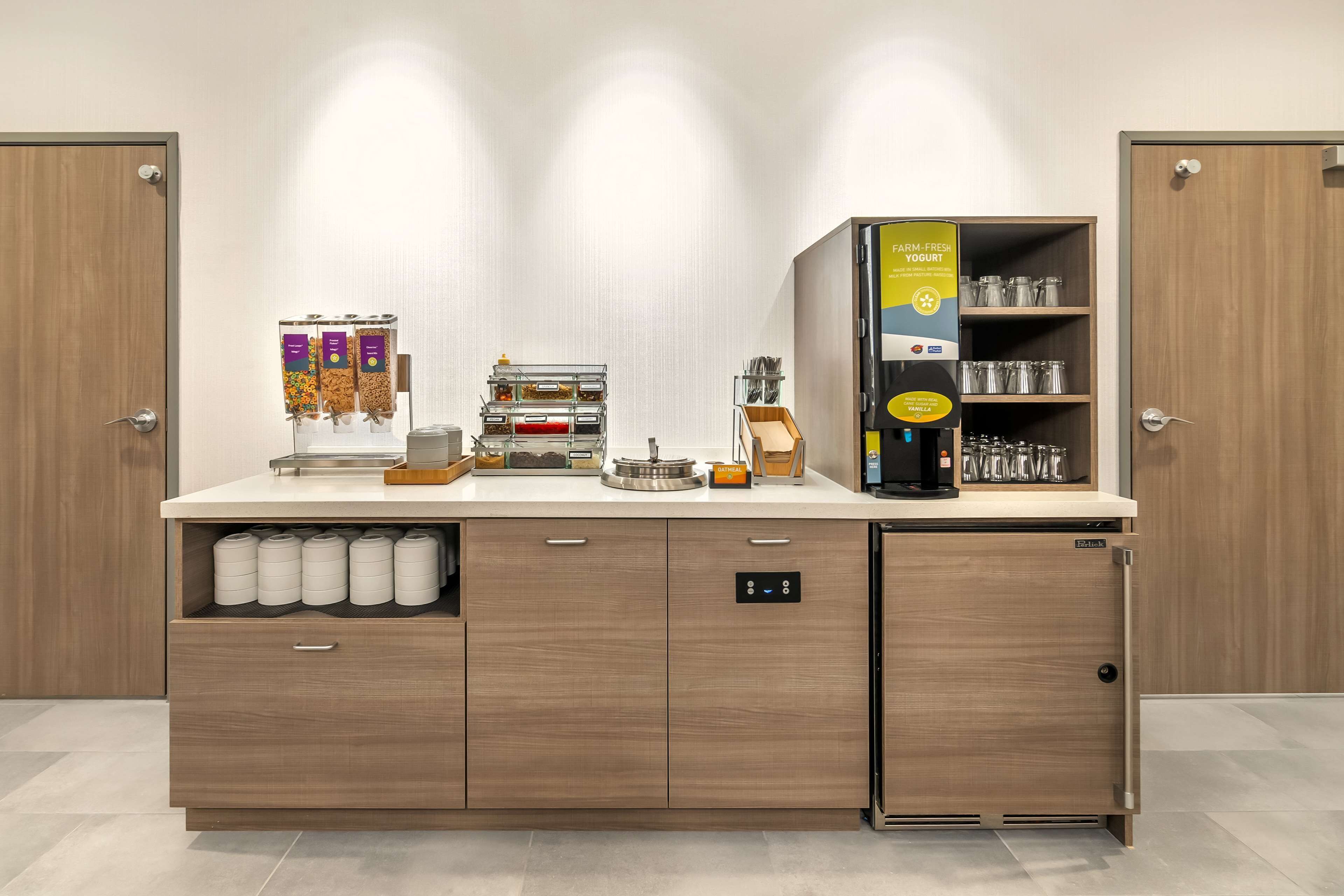 A kitchenette with a coffee machine, tea dispenser, and storage for kitchen essentials.