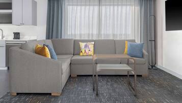 A modern living room with a grey sectional sofa, a small table, and a floor lamp.