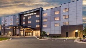 A modern hotel with a prominent entrance, multiple floors, and a well-lit facade. - Homewood Suites Holland (Holland)