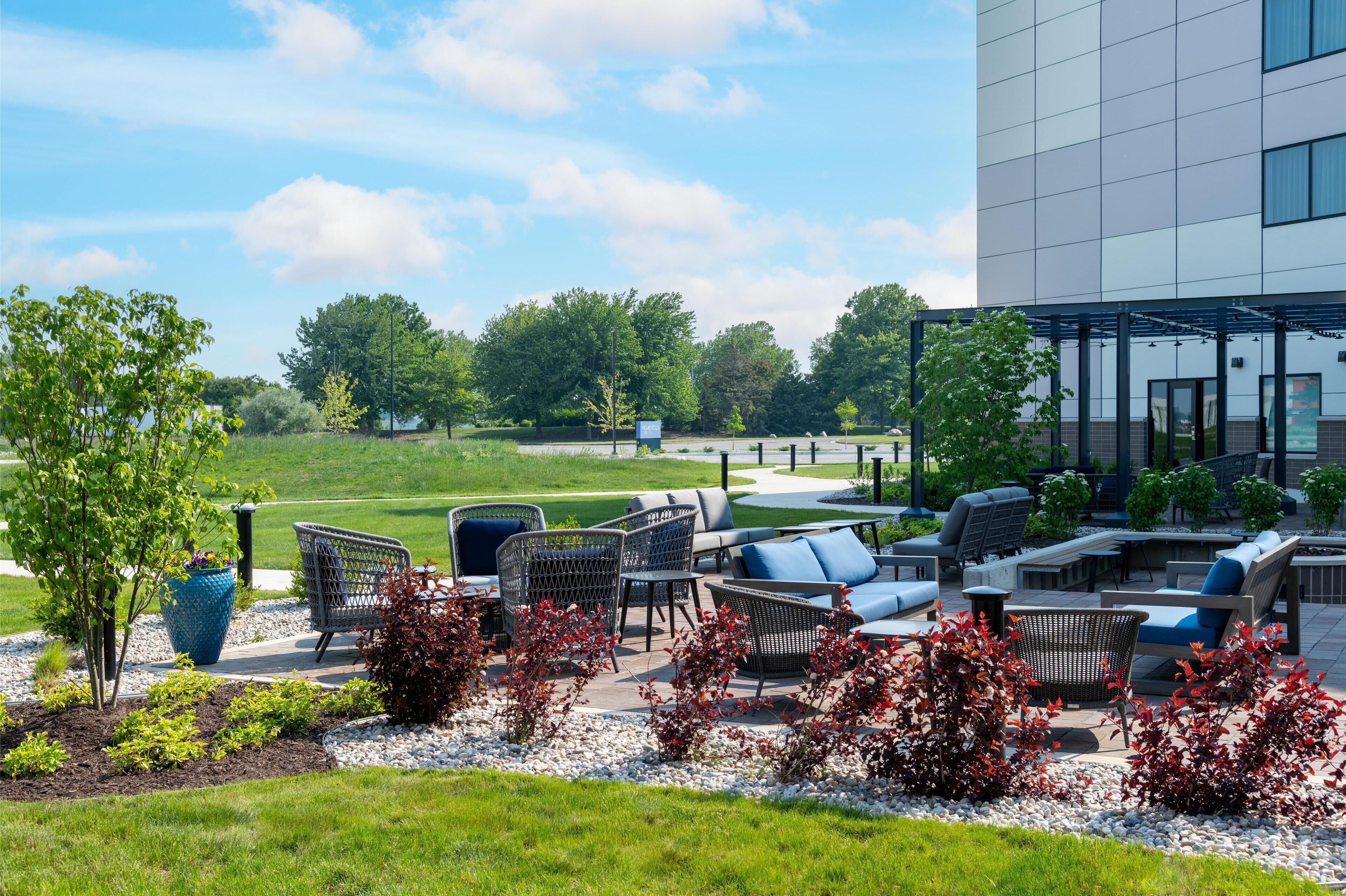 An outdoor seating area with wicker furniture and a view of a golf course.