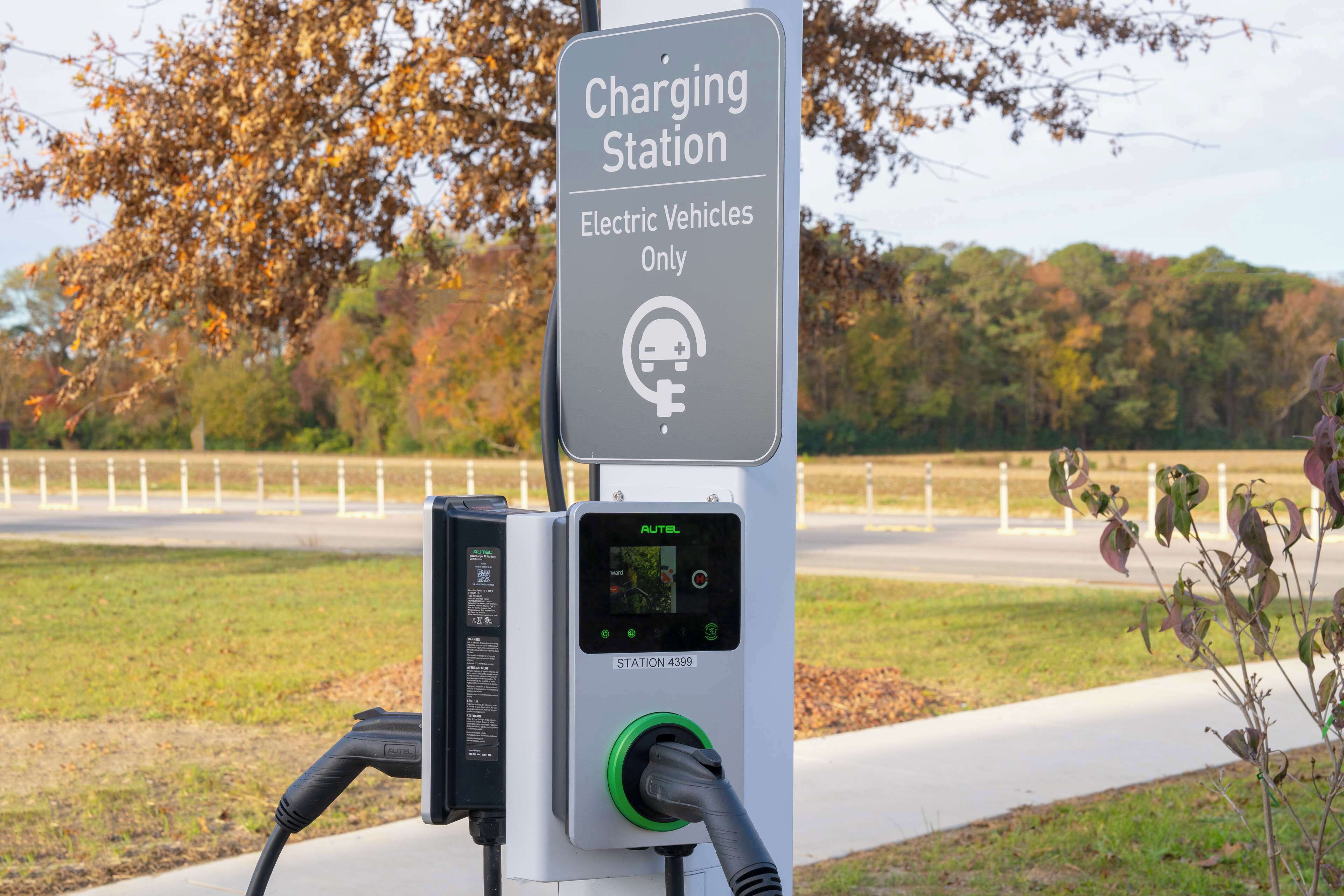 Une borne de recharge pour véhicules électriques, avec un panneau indiquant qu’elle est réservée aux véhicules électriques.