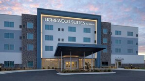 Ein modernes Hotelgebäude mit dem Schild "Homewood Suites by Hilton" und einem überdachten Eingang.