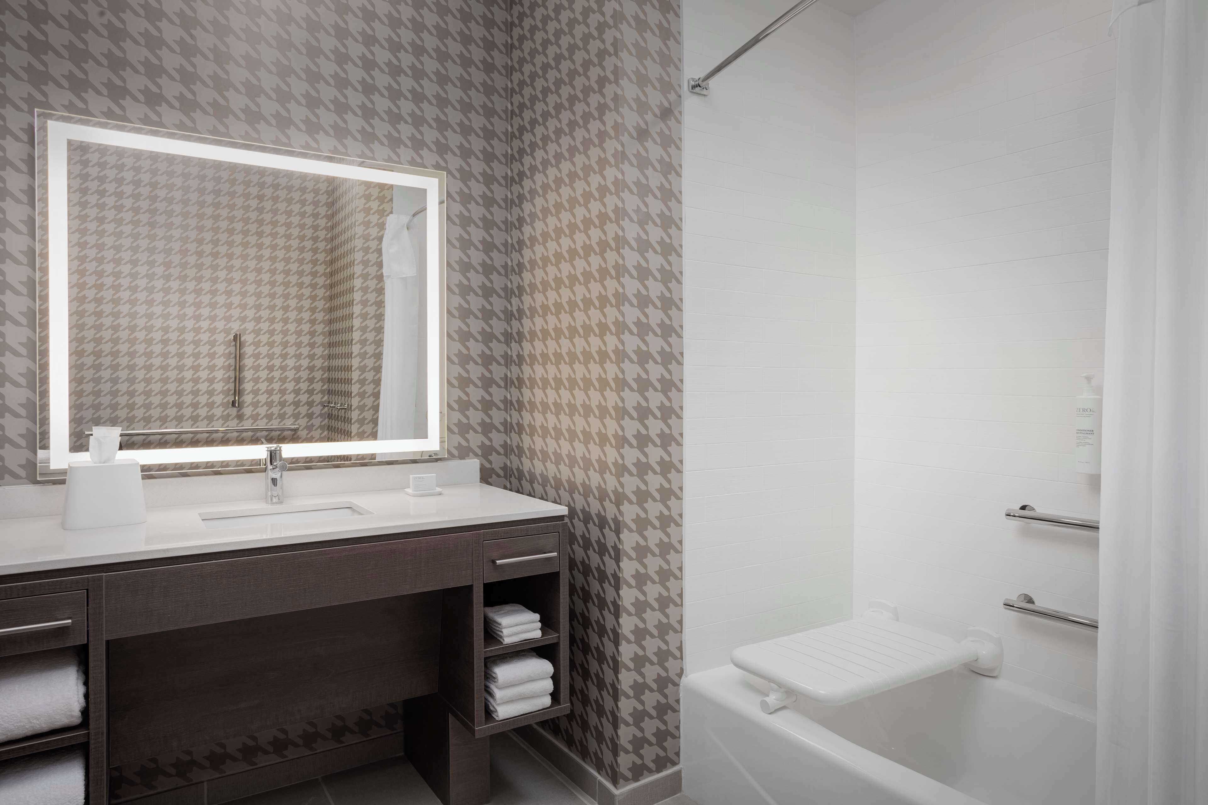 Ein modernes Badezimmer mit großem Spiegel, Waschbecken, Dusche und Toilette.