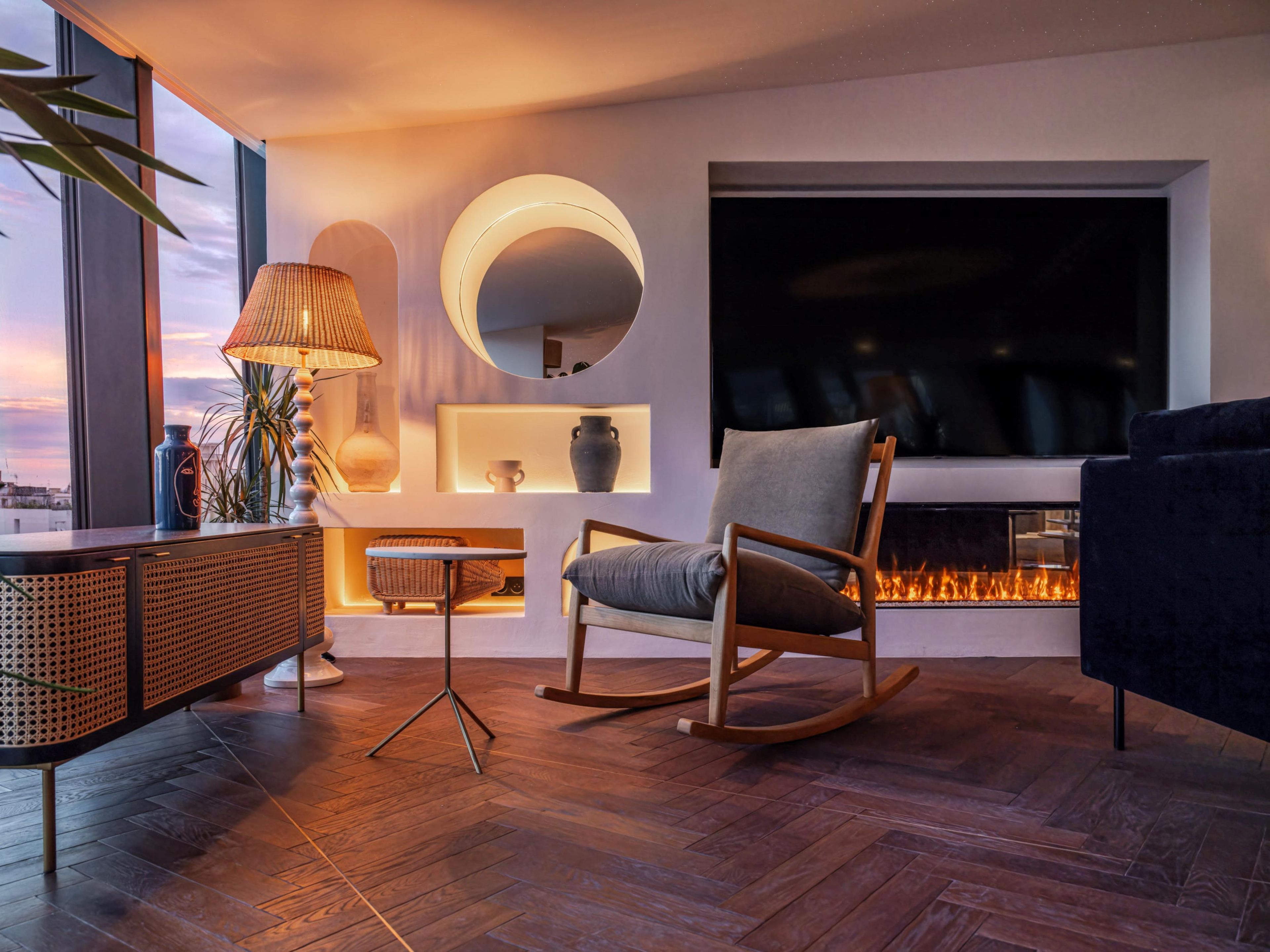 Una sala moderna con un televisor grande, una chimenea y un espacio de estar acogedor.