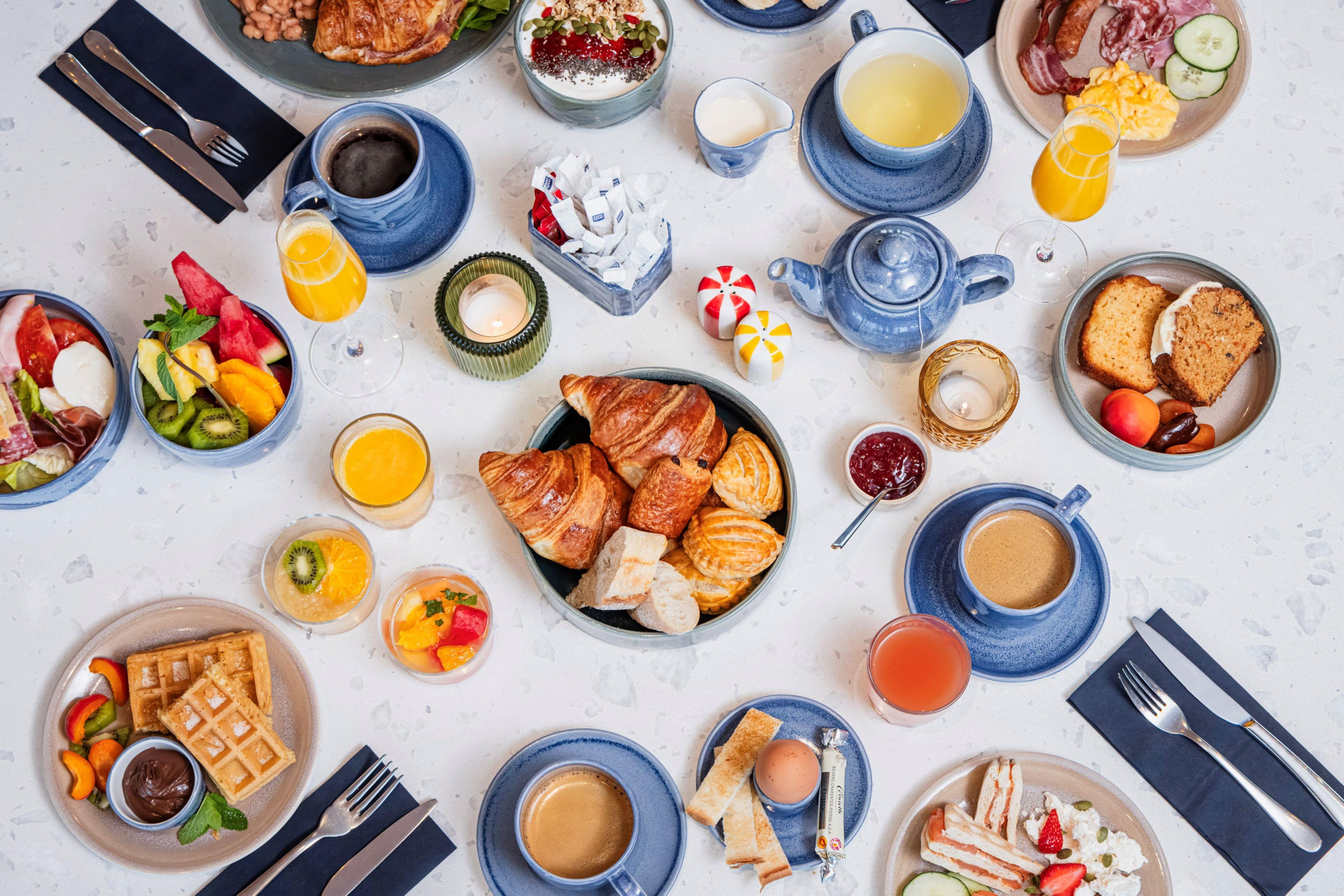 A breakfast spread with various food items and beverages.