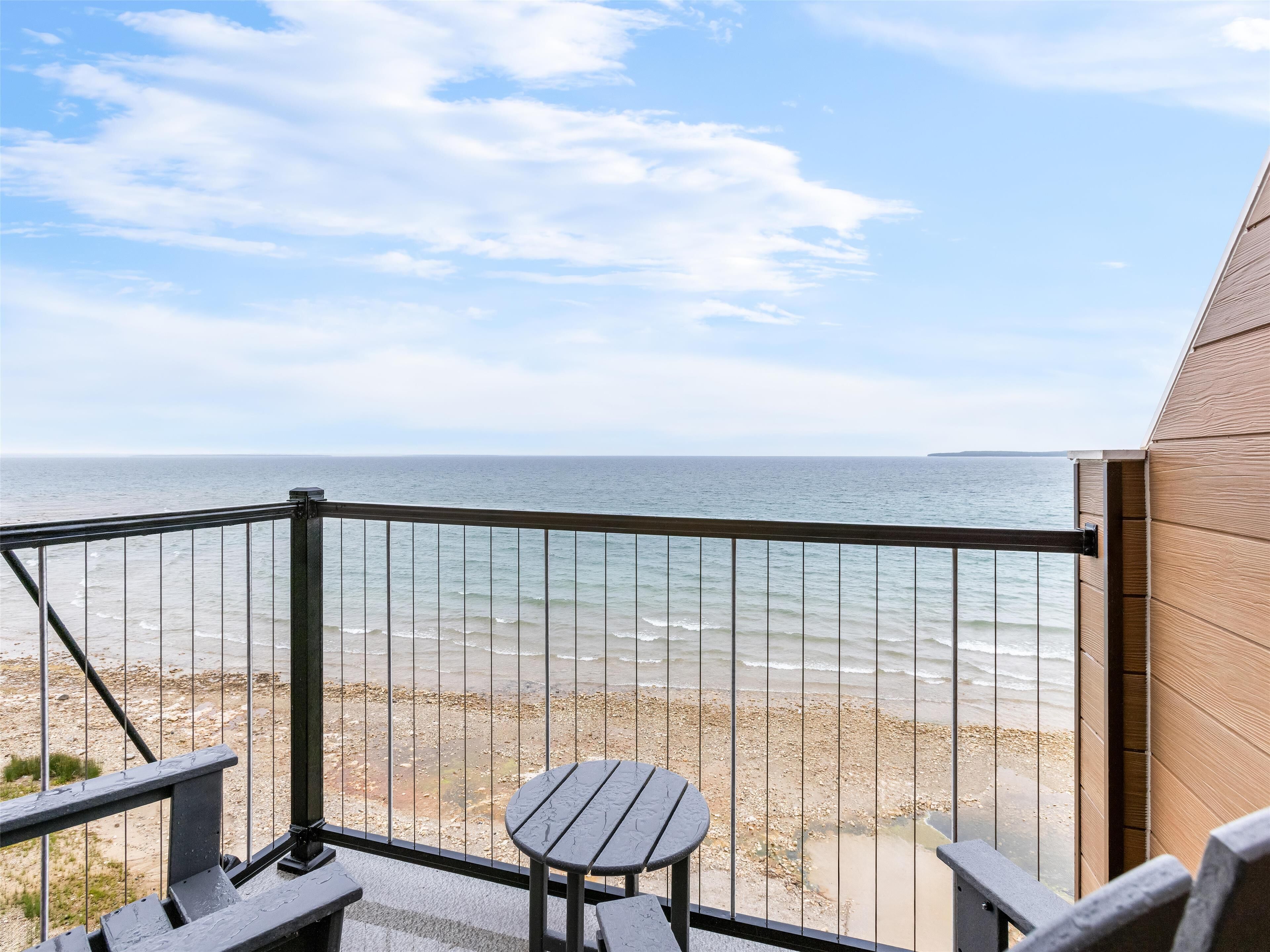 Een balkon met uitzicht op het strand en de oceaan.