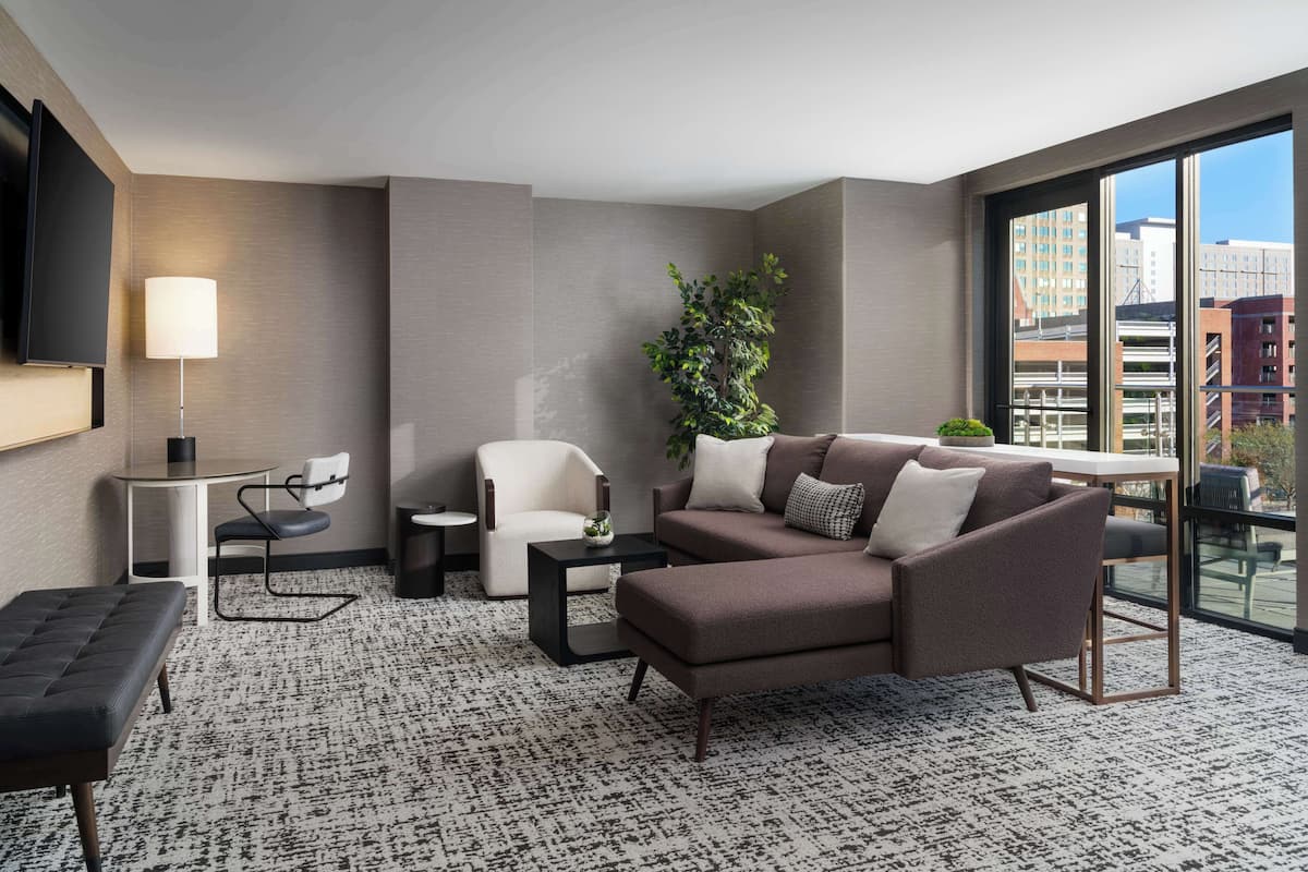 A modern living room with a sofa, armchair, and a small table.