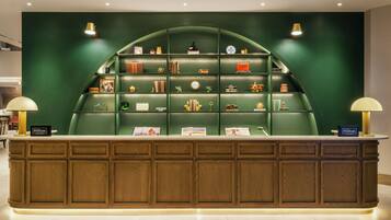 A reception desk with a green backdrop and a wooden panel design.