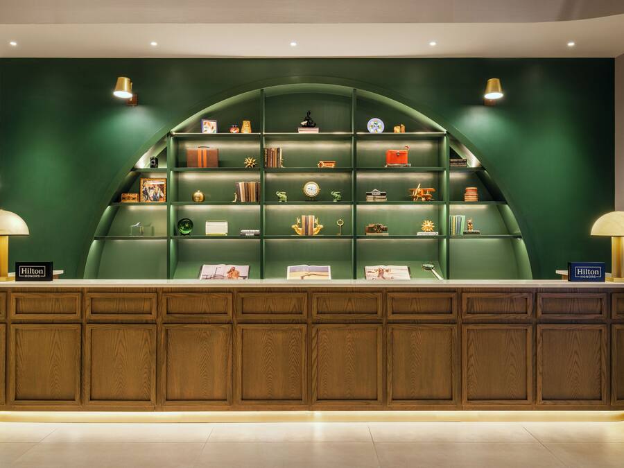 A reception desk with a green backdrop and a wooden panel design.