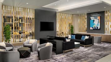 Una sala de estar moderna con un sofá, sillones, una mesa de centro y un televisor.