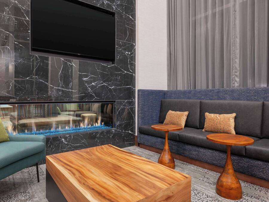 A modern living room with a fireplace, a sofa set, and a coffee table.