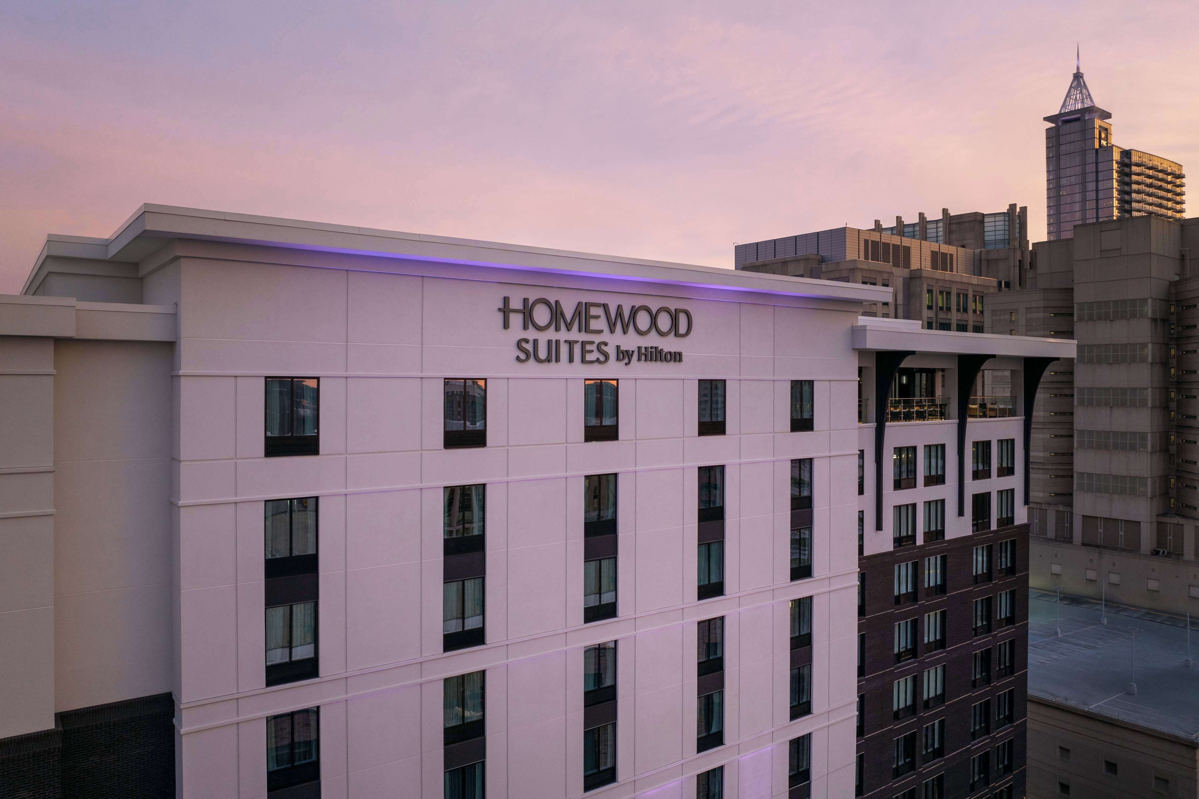 Un bâtiment d’hôtel dont la façade porte l’inscription « HOMEWOOD SUITES by Hilton ».