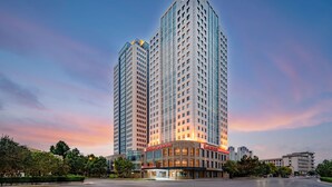 Un hôtel de grande hauteur au design moderne, comprenant de nombreux étages et une entrée imposante.