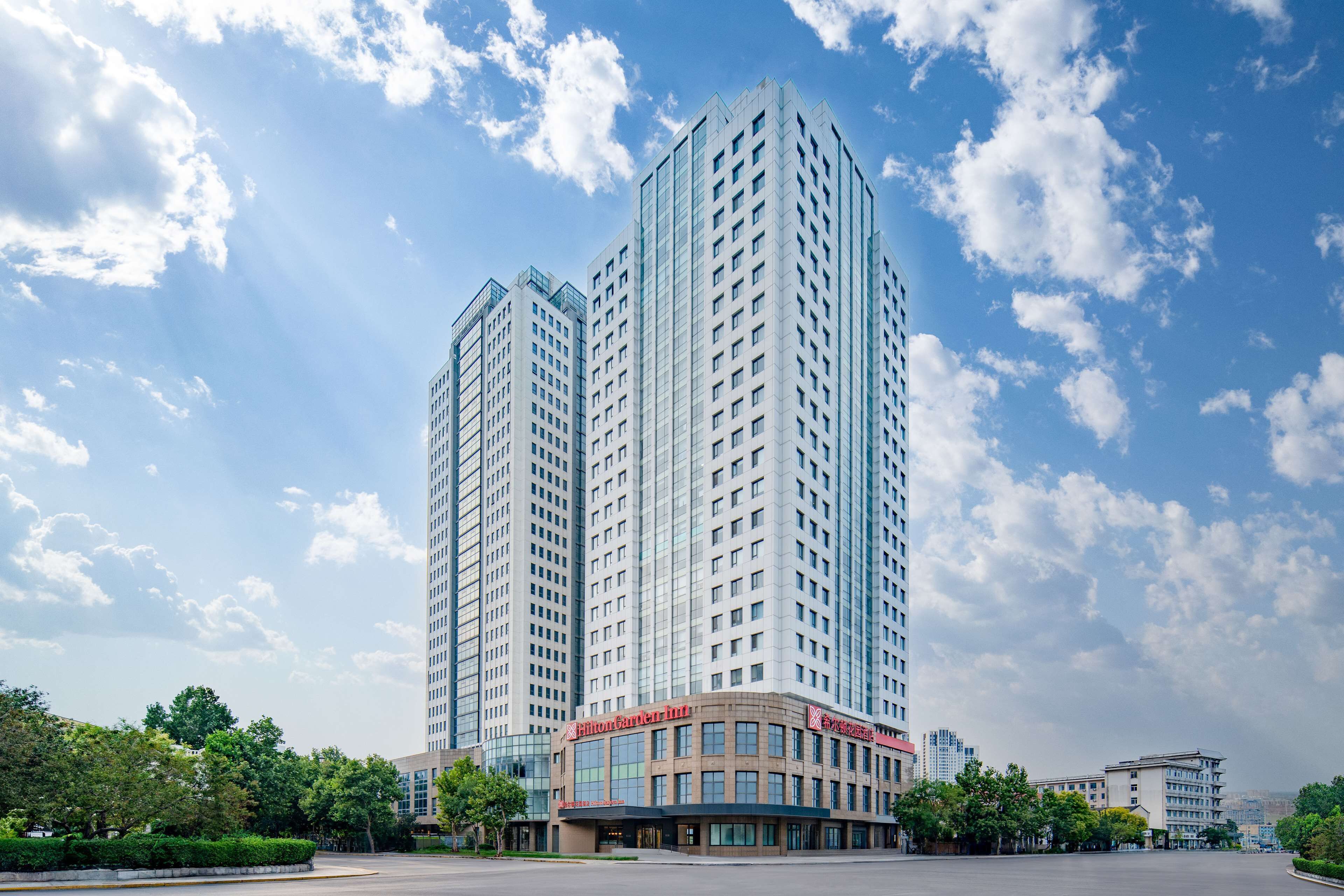 A high-rise hotel with multiple floors, featuring a prominent entrance with signage.