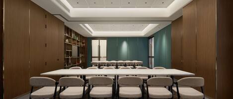 A conference room with a long table and chairs, wooden paneling, and a modern ceiling design.