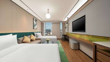 A modern hotel room with two beds, a desk, a TV, and a view of the city skyline.