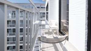 A balcony with white railings, a table, and chairs. - Cozy Studio With Terrace and Stunning View (Middelkerke)