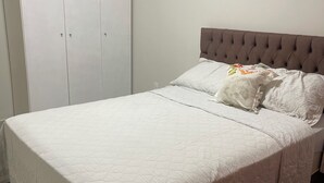 A bedroom with a large bed, a wardrobe, and a plain wall. - Casinha33, O Aconchego da Tríplice Fronteira! (Jardim Cataratas Foz do Iguaçu)