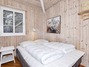 A bedroom with a bed, a window, a wall-mounted lamp, and a painting. - 4 Star Holiday Home in Thisted (Thisted)