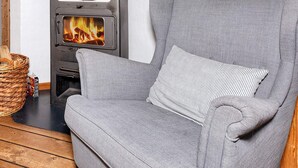 Une pièce chaleureuse avec un canapé gris et une cheminée.