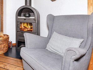 Una habitació acollidora amb un sofà gris i una llar de foc.