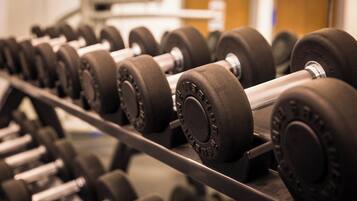 A rack of black dumbbells with adjustable weights.