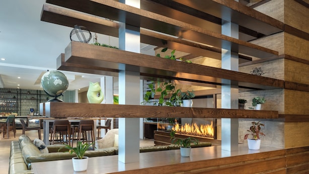 Un interior moderno con un mostrador de recepción de madera, un área de descanso y una chimenea.