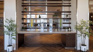Una cocina moderna con una isla central, suelo de madera en espiga y plantas en macetas.