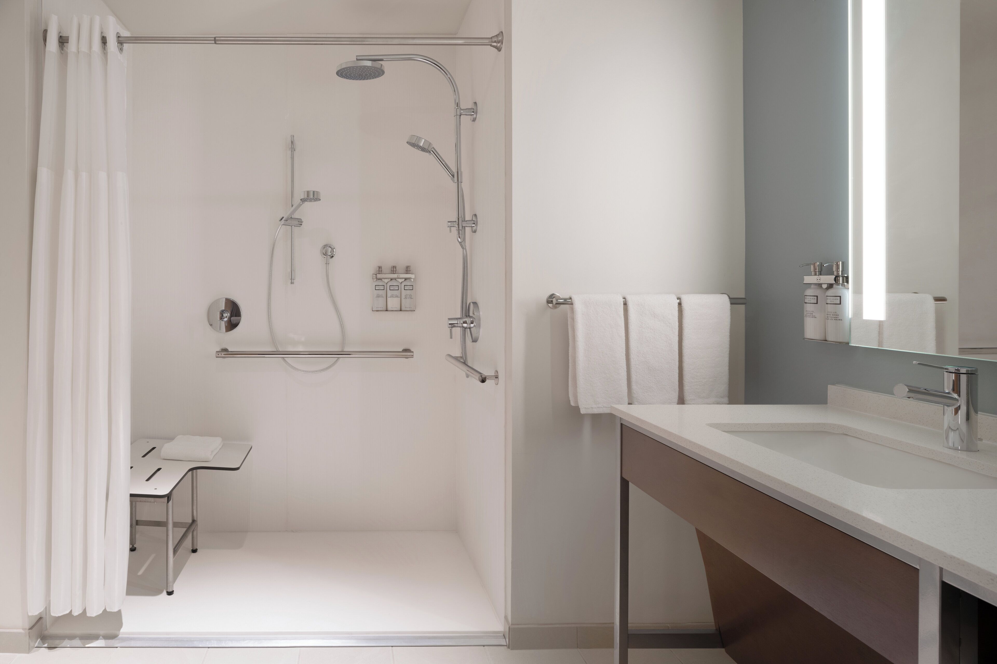 Un baño moderno con ducha, inodoro y lavamanos.
