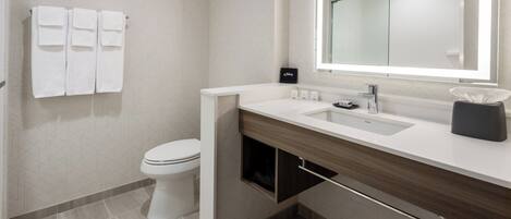 Een moderne badkamer met een toilet, een wastafel en een spiegel.