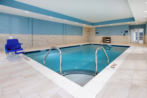 Une piscine intérieure à l’eau claire, décorée dans des tons de bleu et de blanc, et dotée d’un poste de surveillance pour le sauveteur.