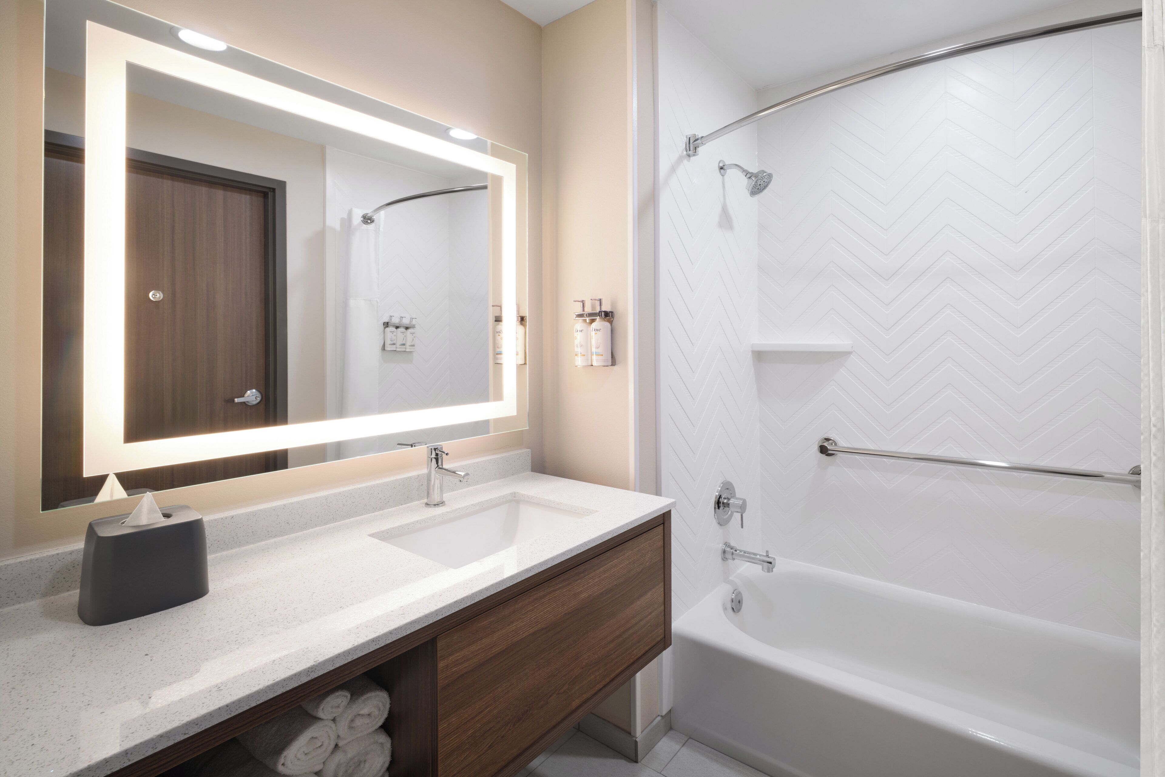 Un baño con dos lavamanos, un espejo, toallero y ducha.