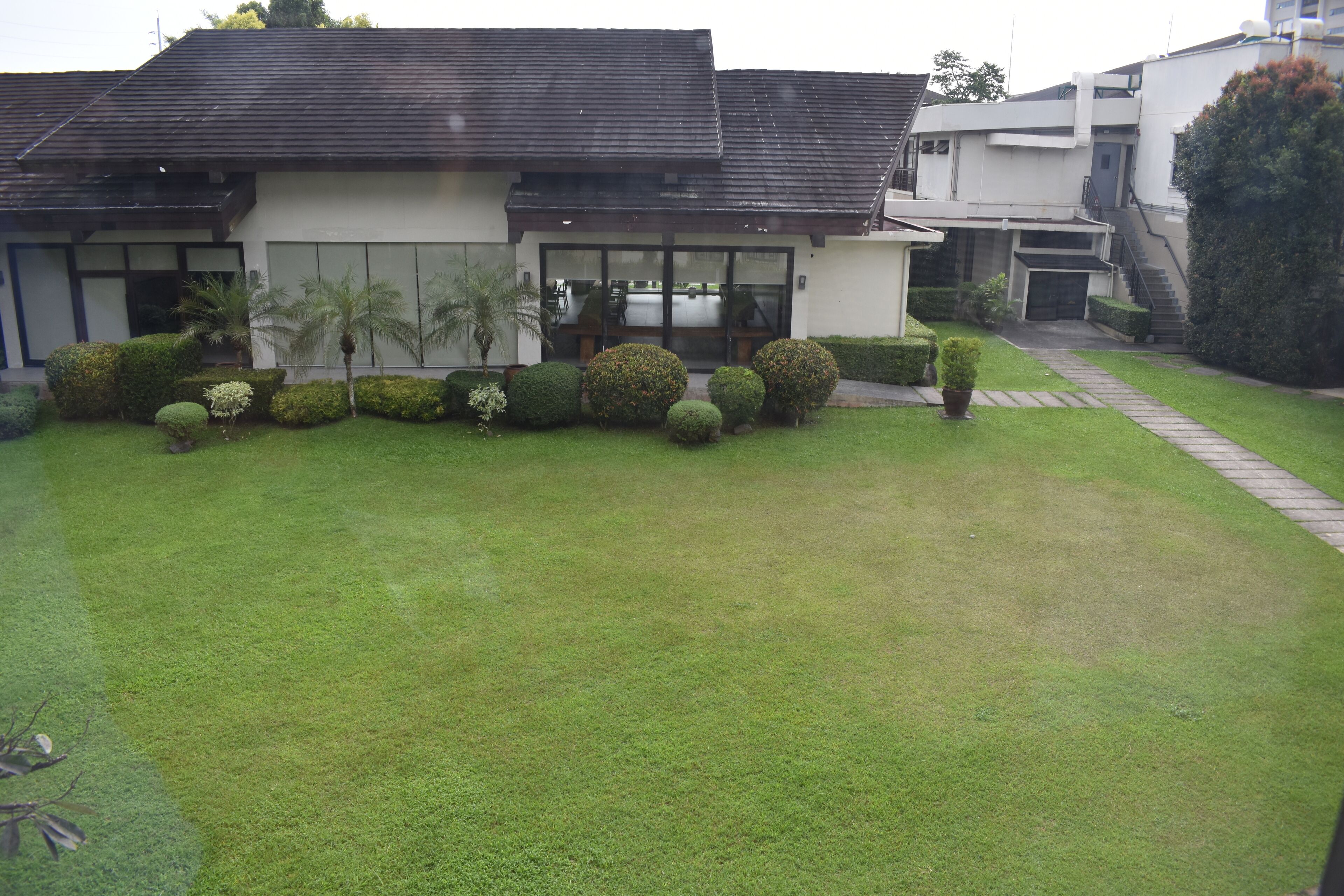 A modern building with a well-maintained lawn and a variety of shrubs.