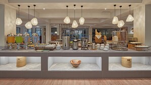A buffet area with various food items and serving ware, including bowls, plates, and containers. - Holiday Inn & Suites Batangas Limapark by IHG (Malvar)