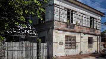 A two-story building with a sign reading 'Casa de Segunda' and the year '1880' on the gate.