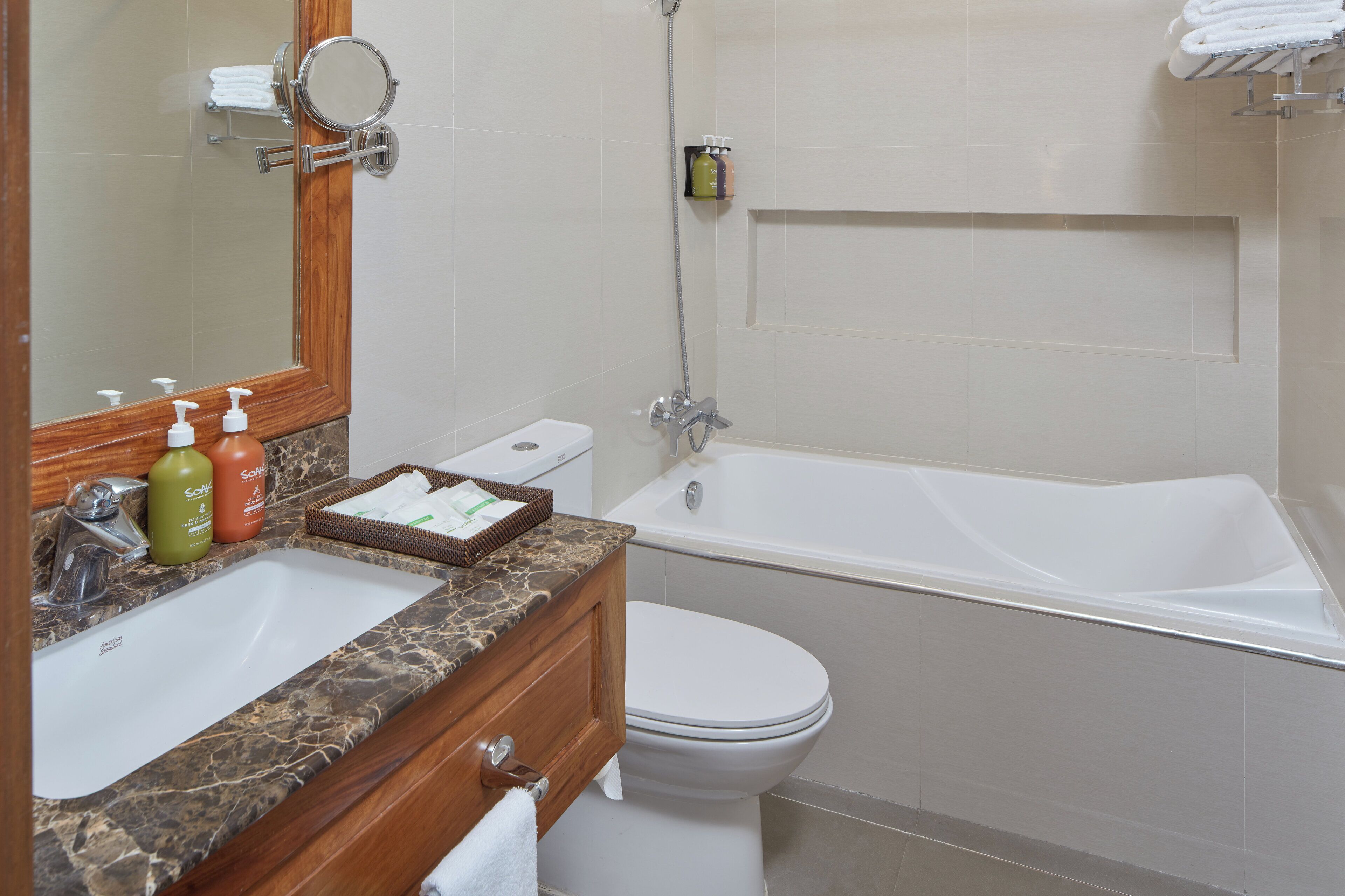 Un baño con lavamanos de mármol, inodoro y bañera.