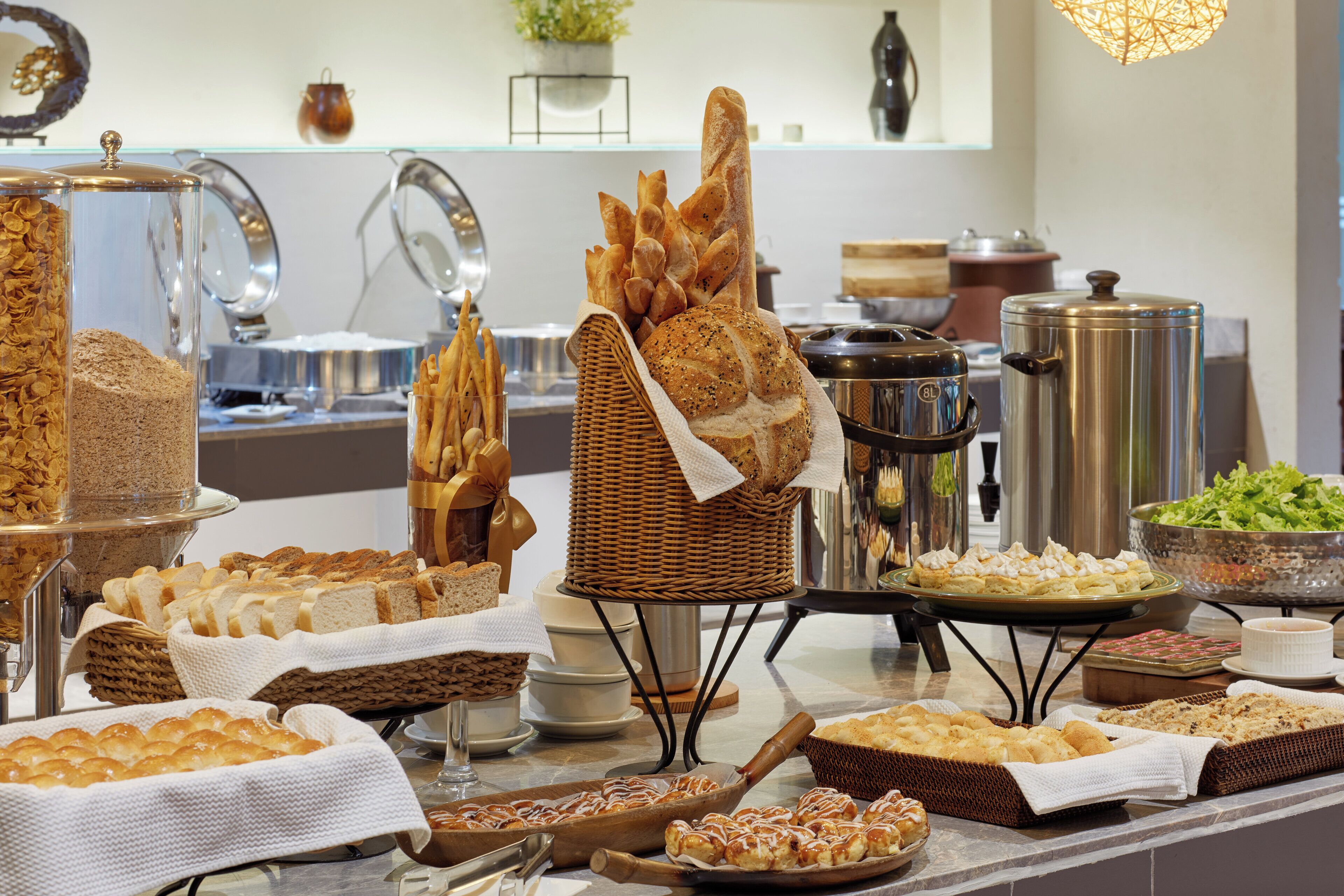 A buffet with various food items including bread, pastries, and salads.