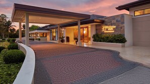 A hotel entrance with a covered walkway, a stone facade, and a sign indicating it is a Holiday Inn Express. - Holiday Inn & Suites Batangas Limapark by IHG (Malvar)