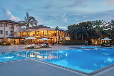 Una piscina al aire libre, camas de piscina gratis, sombrillas