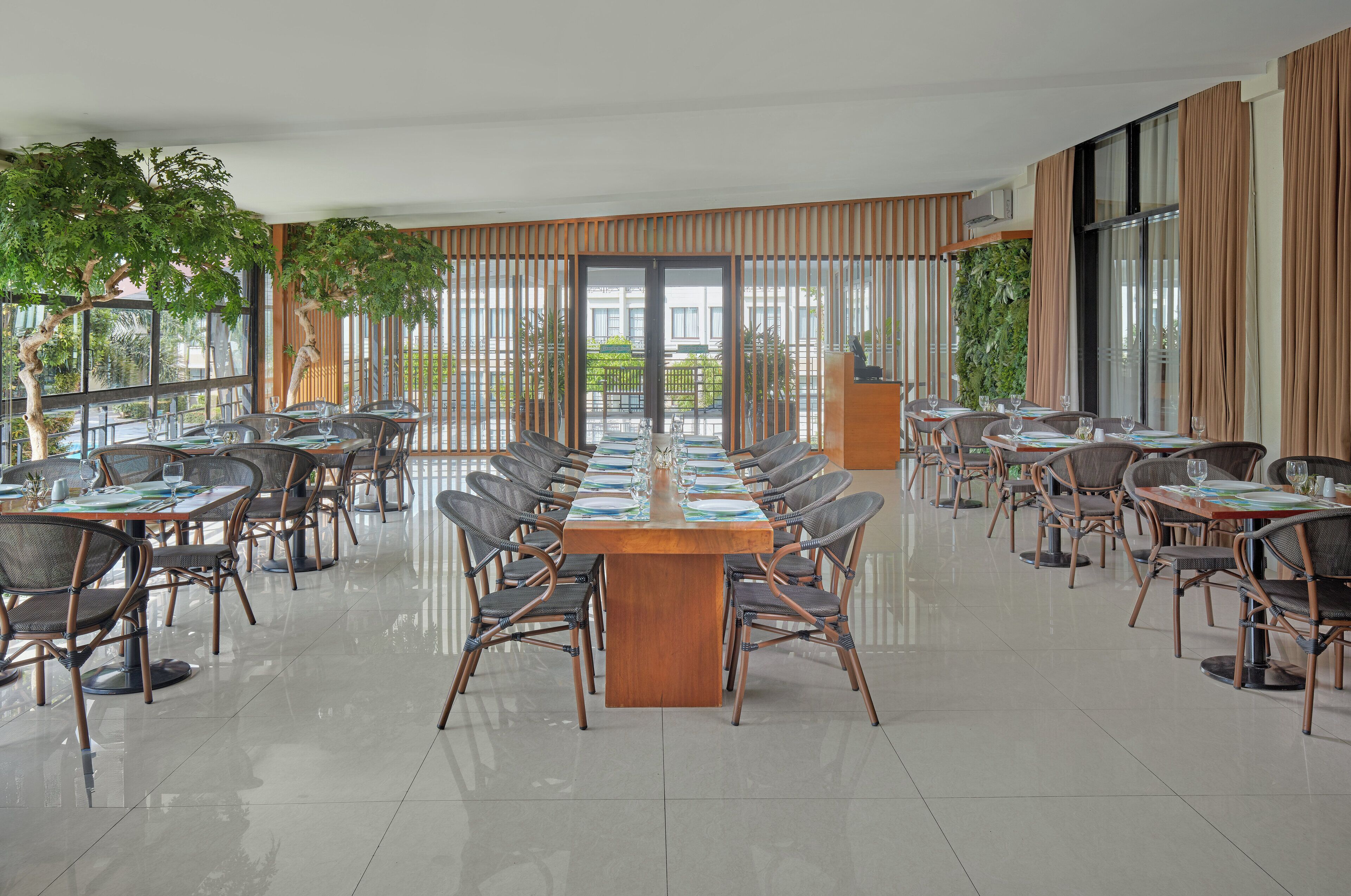 A spacious conference room with a long table and chairs, large windows, and a view of the outdoors.