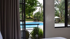 A hotel room with a view of a swimming pool, a gazebo, and lush greenery. - Holiday Inn & Suites Batangas Limapark by IHG (Malvar)