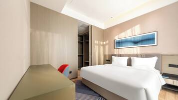 Una habitación de hotel moderna con una cama grande, un escritorio y un vestidor.
