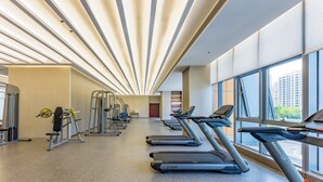 A gym with treadmills, weight machines, and a large window. - Holiday Inn Express Qidong Economic Zone by IHG (Nantong)