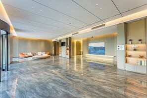 A spacious lobby with a modern design, featuring a seating area with sofas and a large flat-screen TV mounted on the wall. - Holiday Inn Express Qidong Economic Zone by IHG (Nantong)